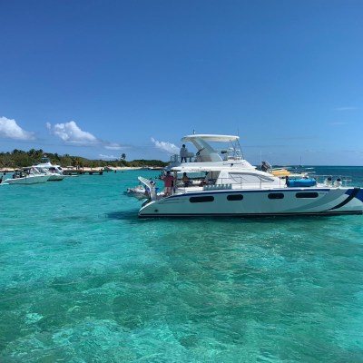 a blue and white boat sitting next to a body of water
