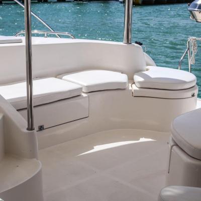 White boat deck seating area with water in the background.