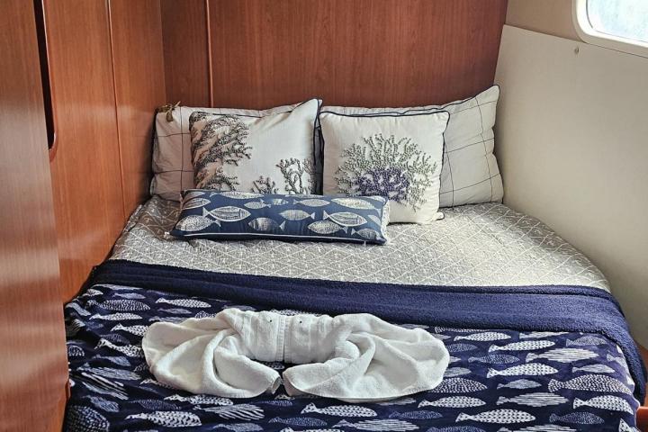 Cozy cabin bed with nautical-themed pillows and blanket.
